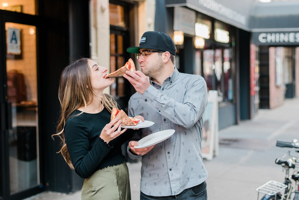 candid of couple enjoying pizza during nyc engagement