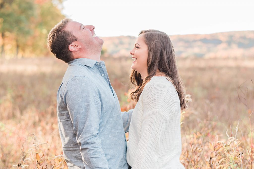 couple enjoys a candid laugh during their engagement session in new paltz