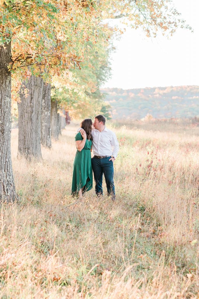 couple kisses from afar during fall engagement session in new york