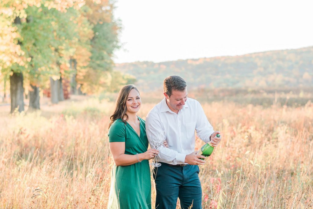 couple does a champagne toast during engagement session in new paltz, new york