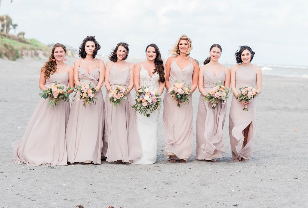 bride and her bridesmaids on the beach for formal shots