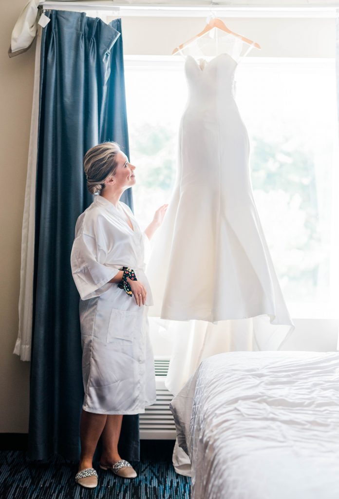 bride admires her gown on wedding day