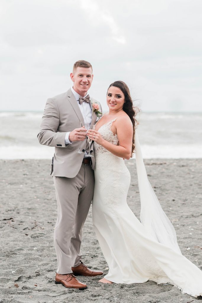 couple shares a toast for beach wedding