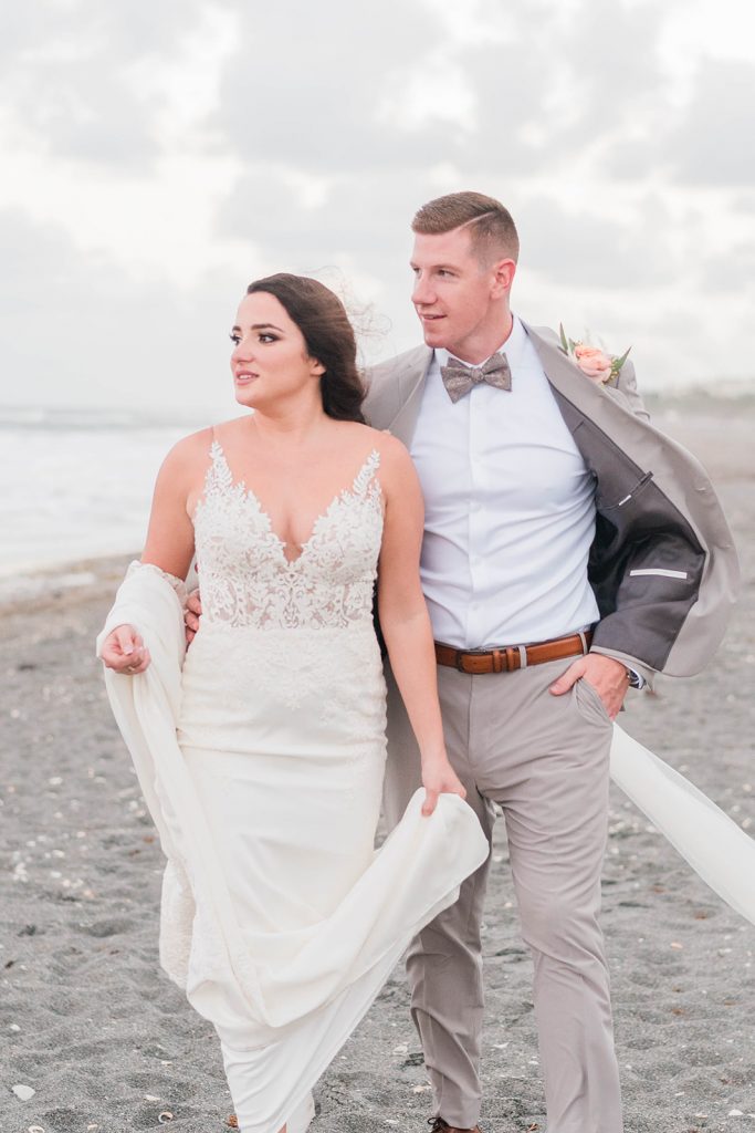 couple has a raw moment during wedding day portraits on beach