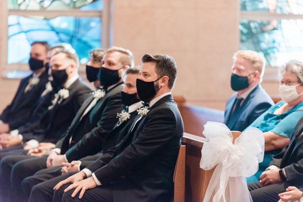 groomsmen look on during ceremony
