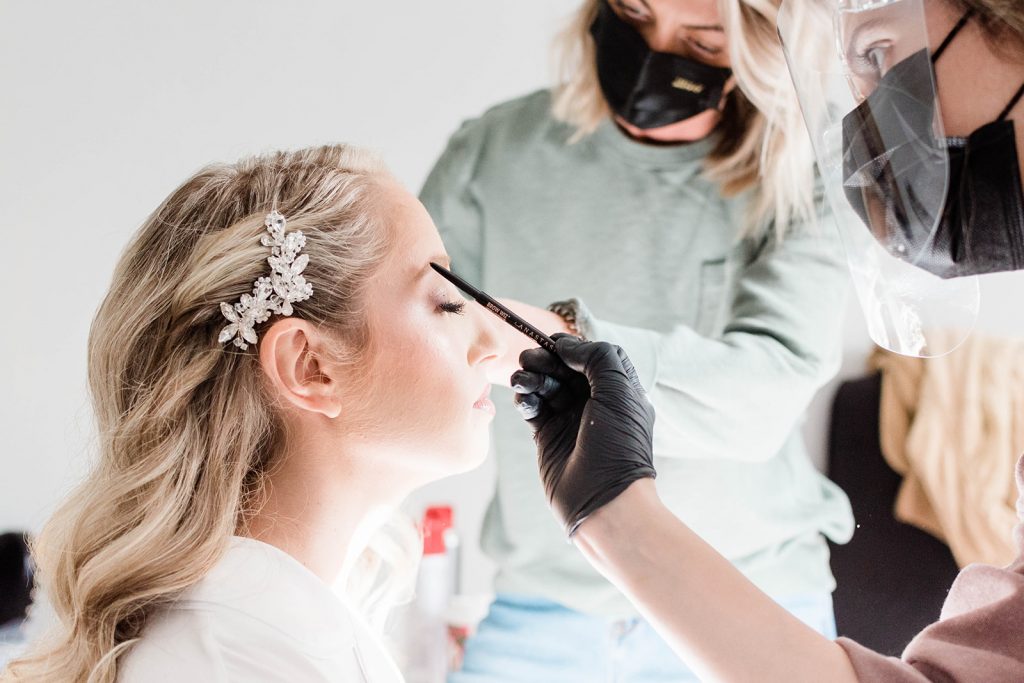 bride gets makeup done in intimate wedding
