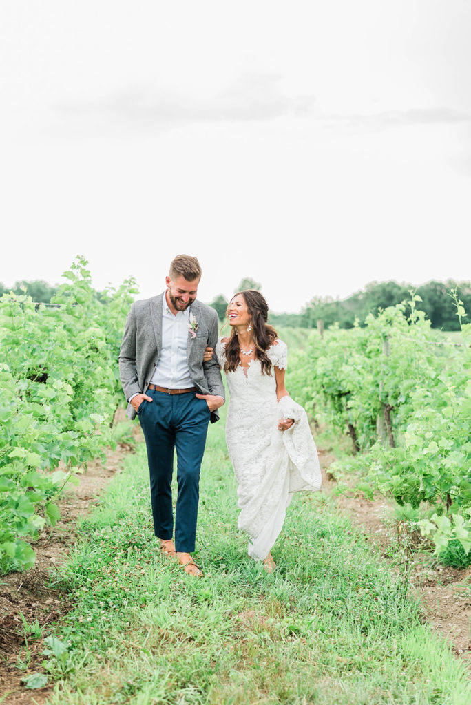 couple strolls through vineyards during hudson valley wedding