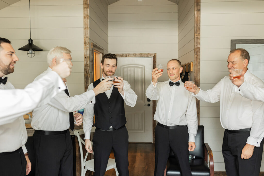 toast between groom and groomsmen on wedding day
